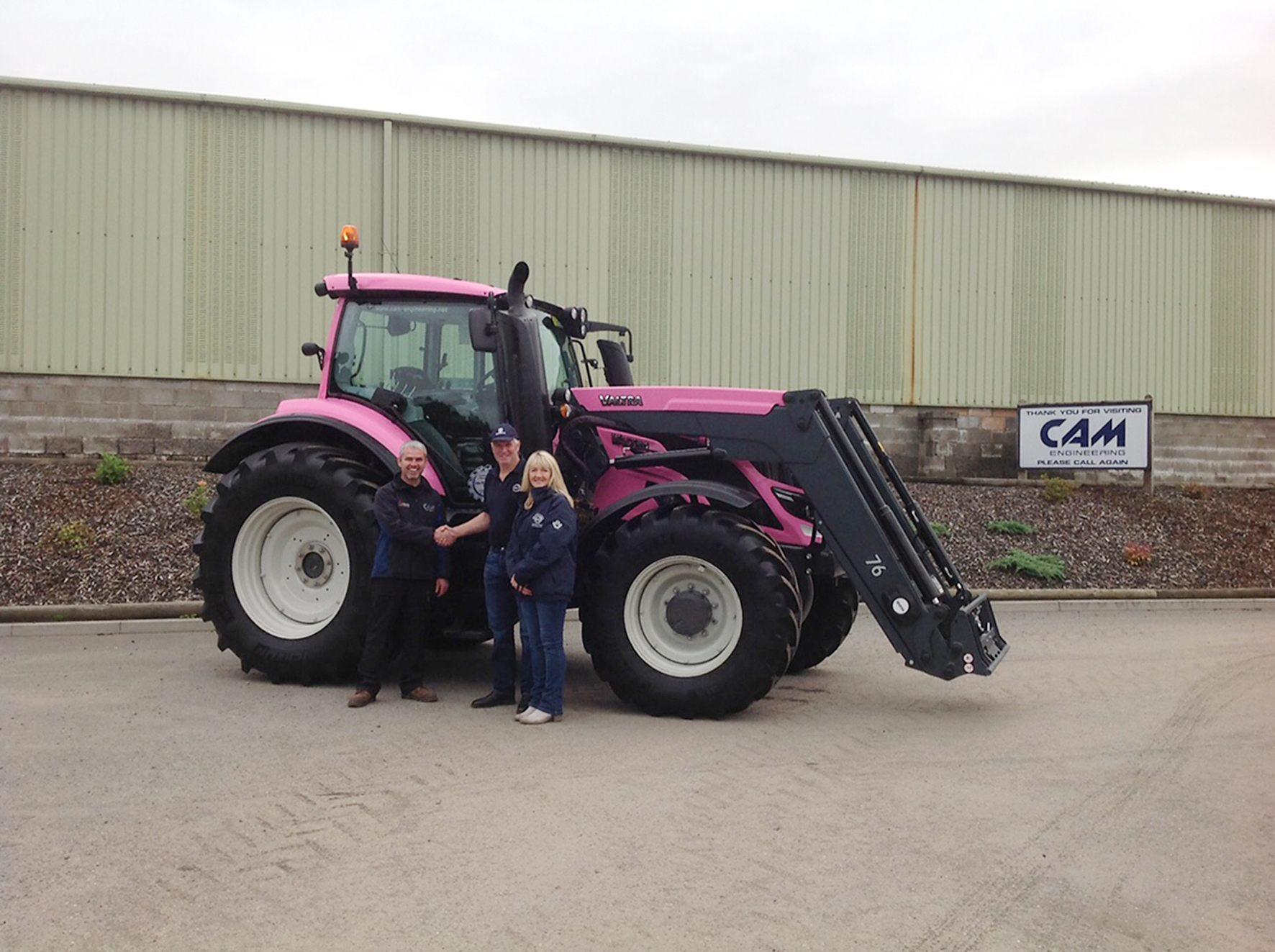 Valtra Pink tractor and front loader. From left: Clive Montgomery (CAM Engineering), John (Jock) & Karen Paterson from J.M.Paterson.